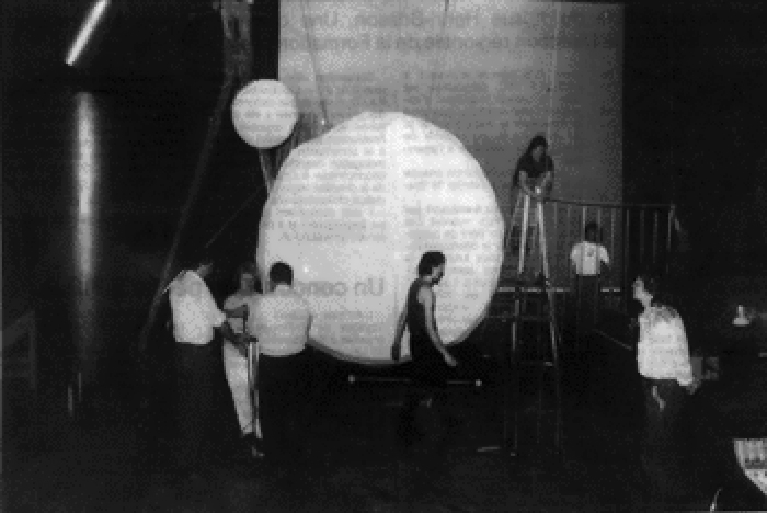 The Ono Lulu Filharmonia (Olga Swajgier, Michal Zduniak, Tadeusz Sudnik, Marcin Krzyzanowski, and Mathius Shadow-Sky) 1990 Bourges performance preparation with Olga Swajgier between the 2 guys adjusting the quadraphonic 4 microphones, Mathius Shadow-Sky in front of the giant drum puppet Ono and Tadeusz Sudnik on the right, his arms behind his back. 